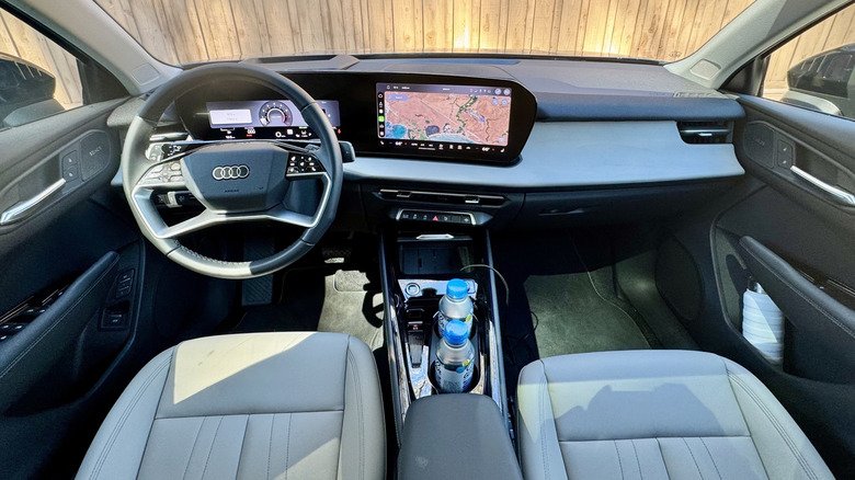 a wide shot of the Q3's new dashboard showing the map on the infotainment screen and a wooden fence out the windshield a wide shot of the Q3's new dashboard showing the map on the infotainment screen and a wooden fence out the windshield