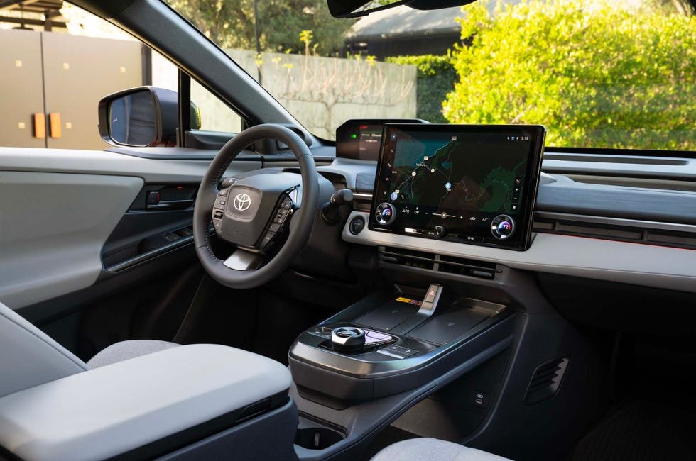 vehicle interior view, gray dashboard touchscreen center console rotary control clean layout.